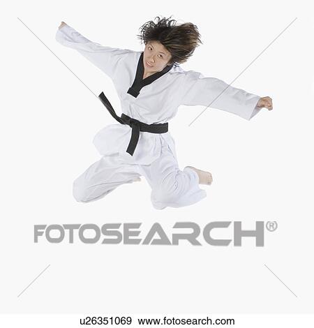 Stock Photo - Portrait of a young woman jumping and practicing martial arts. Fotosearch
