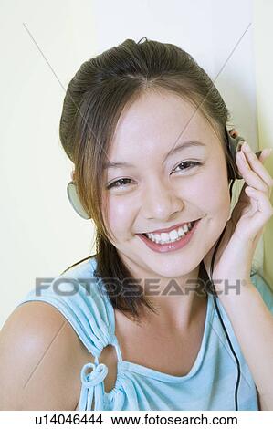 Picture - Portrait of a young woman wearing headphones and listening to music. Fotosearch