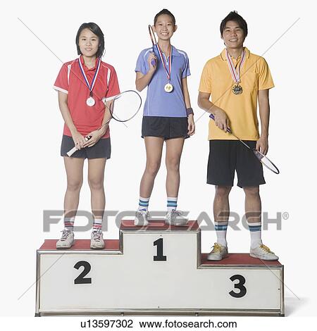 Portrait of two young women and a young man standing on a winners podium and wearing sports medal View Large Photo Image Stock Image - Portrait of two young women and a young man standing on a winners podium and wearing sports medal. Fotosearch