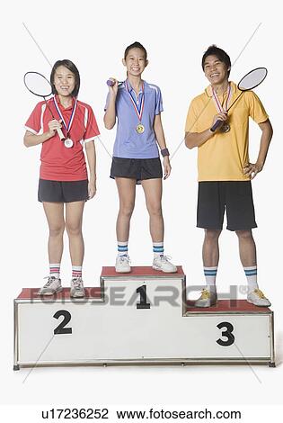 Portrait of two young women and a young man standing on a winners podium and wearing sports medal View Large Photo Image Stock Image - Portrait of two young women and a young man standing on a winners podium and wearing sports medal. Fotosearch