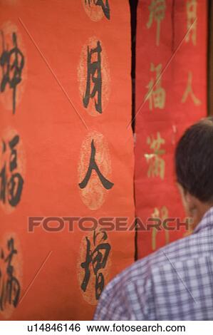 Stock Photograph - Rear view of a man in front of banners, Chuan Lian. Fotosearch