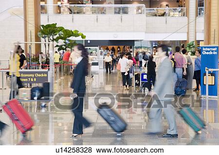 Side profile of a businessman and a businesswoman leaving an airport View Large Photo Image Stock Photo - Side profile of a businessman and a businesswoman leaving an airport. Fotosearch