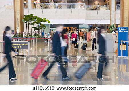 Side profile of a businessman and two businesswomen leaving an airport View Large Photo Image Stock Photo - Side profile of a businessman and two businesswomen leaving an airport. Fotosearch