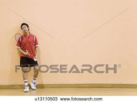 Young man holding a badminton racket and a shuttlecock View Large Photo Image Stock Image - Young man holding a badminton racket and a shuttlecock. Fotosearch