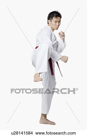 Picture - Young man in side kick position. Fotosearch