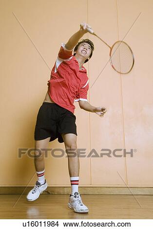 Picture - Young man playing badminton. Fotosearch