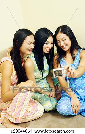 Young woman and her two friends taking a photograph of themselves View Large Photo Image Stock Image - Young woman and her two friends taking a photograph of themselves. Fotosearch