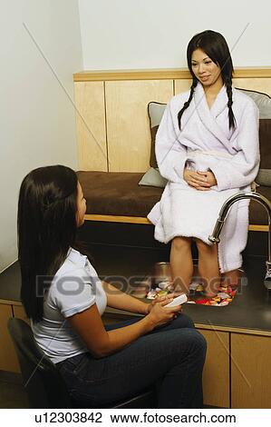 Stock Image - Young woman getting a pedicure. Fotosearch