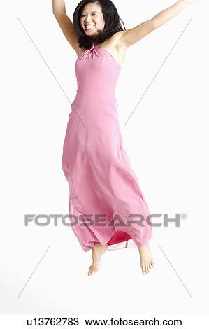 Stock Image - Young woman jumping and smiling. Fotosearch