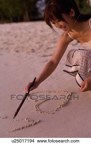 Woman writing on sand, Saipan, USA View Large Photo Image Picture - Woman writing on sand, Saipan, USA . Fotosearch