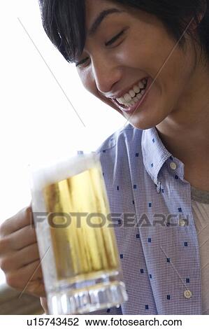 Stock Image - Young man holding a beer, Saipan. Fotosearch