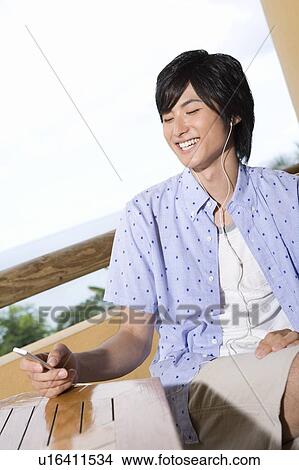 Picture - Young man listening to music, Saipan. Fotosearch