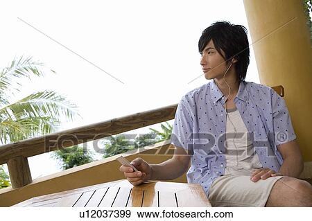 Stock Photo - Young man listening to music, Saipan. Fotosearch