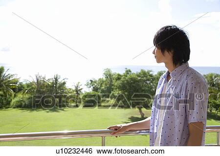 Stock Photograph - Young man looking at the View, Saipan. Fotosearch