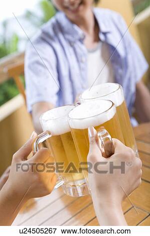 Stock Photo - Young people toasting with beer, Saipan, Focus on Foreground. Fotosearch