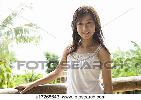 Stock Image - Young woman by the balcony, Siapan. Fotosearch