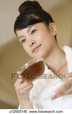 Stock Image - Young woman drinking tea, Saipan. Fotosearch