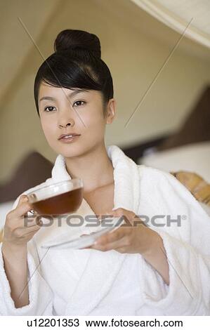 Stock Image - Young woman drinking tea, Saipan. Fotosearch