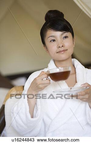 Stock Image - Young woman drinking tea, Saipan. Fotosearch