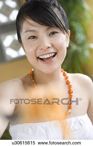Stock Photography - Young woman eating food, Saipan, Focus on Background. Fotosearch