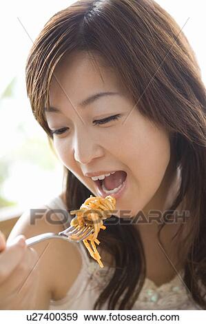 Stock Photo - Young woman eating food, Saipan. Fotosearch