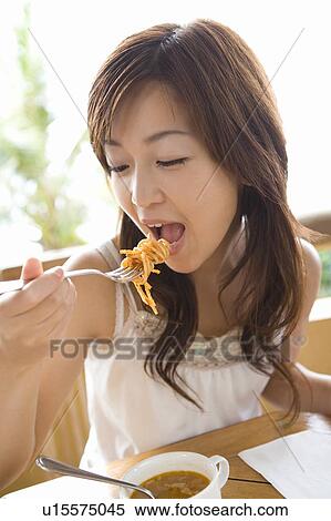 Stock Photography - Young woman eating food, Saipan. Fotosearch