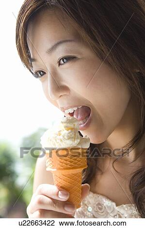 Stock Image - Young woman eating ice cream, Saipan. Fotosearch