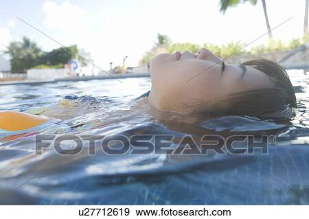 Young woman floating in swimming pool, Saipan View Large Photo Image Stock Photo - Young woman floating in swimming pool, Saipan. Fotosearch