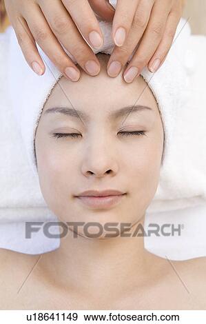 Stock Photo - Young woman getting a facial massage, Saipan. Fotosearch