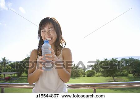 Young woman holding a Water Bottle, Saipan View Large Photo Image Stock Photo - Young woman holding a Water Bottle, Saipan. Fotosearch