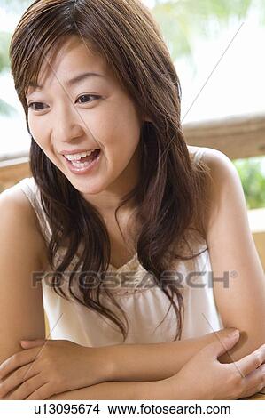 Picture - Young woman sitting at balcony, Saipan. Fotosearch