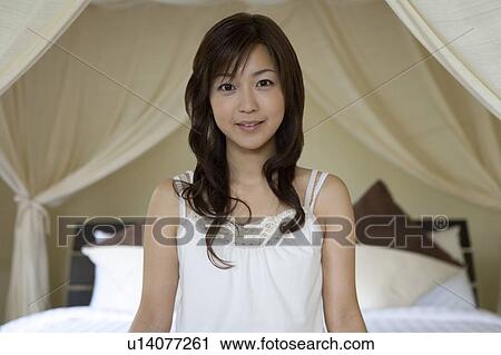 Young woman sitting on a bed, Saipan View Large Photo Image Stock Image - Young woman sitting on a bed, Saipan. Fotosearch