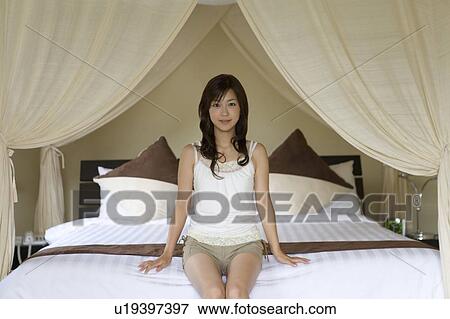 Young woman sitting on a bed, Saipan View Large Photo Image Stock Photo - Young woman sitting on a bed, Saipan. Fotosearch