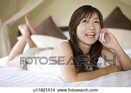 Young woman using a cell phone, Saipan, Focus on Foreground View Large Photo Image Picture - Young woman using a cell phone, Saipan, Focus on Foreground. Fotosearch