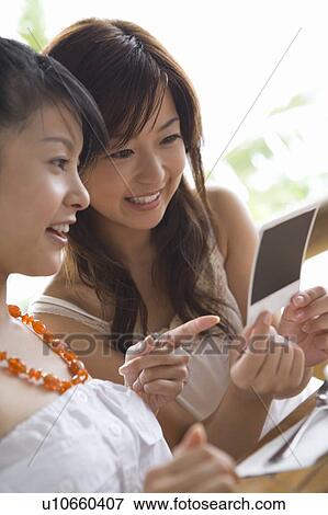 Young women looking at photograph, Saipan View Large Photo Image Stock Photo - Young women looking at photograph, Saipan. Fotosearch