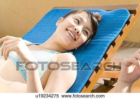 Young women lying on beach chairs, Saipan View Large Photo Image Stock Photography - Young women lying on beach chairs, Saipan. Fotosearch