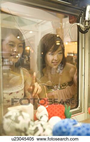 Stock Photography - Young women playing toy grabbing game, Saipan. Fotosearch