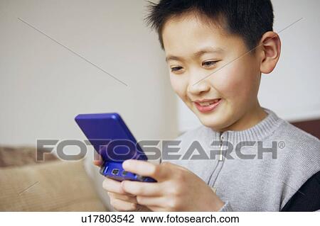 Stock Image - Close-up of a boy playing a video game. Fotosearch
