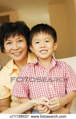 Stock Photo - Close-up of a boy smiling and sitting with his grandmother. Fotosearch