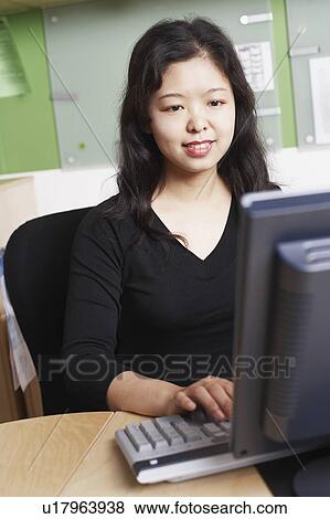 Close-up of a businesswoman using a computer smiling View Large Photo Image Stock Photo - Close-up of a businesswoman using a computer smiling. Fotosearch