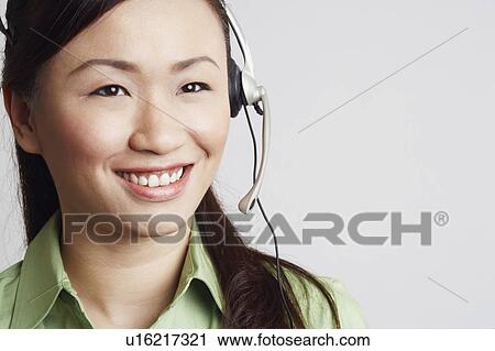 Close-up of a female customer service representative looking away and smiling View Large Photo Image Stock Image - Close-up of a female customer service representative looking away and smiling. Fotosearch