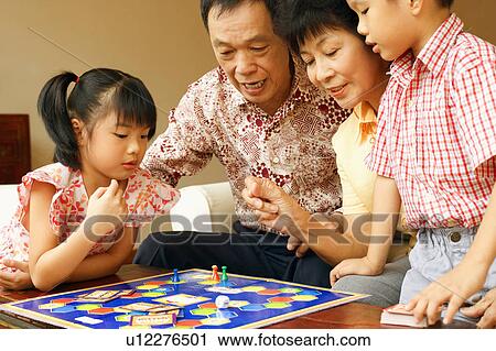 Close-up of a girl and a boy playing game with their grandparents View Large Photo Image Stock Image - Close-up of a girl and a boy playing game with their grandparents. Fotosearch
