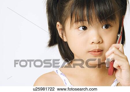 Close-up of a girl holding a mobile phone View Large Photo Image Stock Image - Close-up of a girl holding a mobile phone. Fotosearch