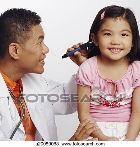 Stock Photo - Close-up of a male doctor examining his patient. Fotosearch
