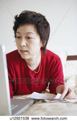 Close-up of a mature woman using a laptop View Large Photo Image Stock Photo - Close-up of a mature woman using a laptop. Fotosearch
