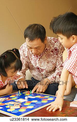 Close-up of a senior man playing a game with his grandchildren View Large Photo Image Picture - Close-up of a senior man playing a game with his grandchildren. Fotosearch