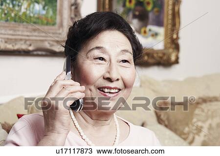 Stock Image - Close-up of a senior woman talking on a mobile phone. Fotosearch