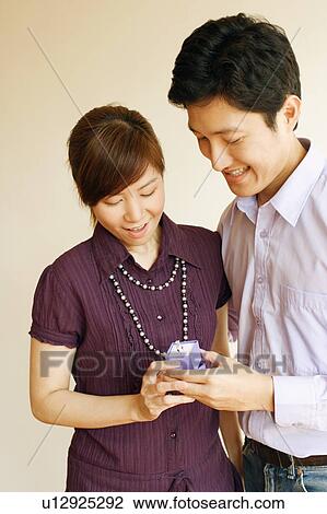 Close-up of a young couple looking at a ring View Large Photo Image Stock Image - Close-up of a young couple looking at a ring. Fotosearch