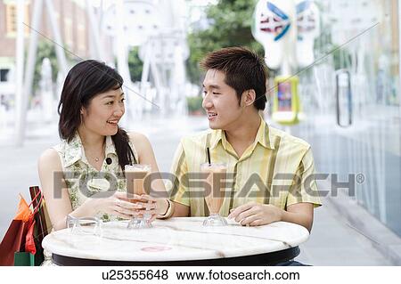 Stock Photo - Close-up of a young couple sitting in a cafeteria. Fotosearch