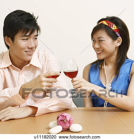 Close-up of a young couple toasting glasses of wine and smiling View Large Photo Image Stock Image - Close-up of a young couple toasting glasses of wine and smiling. Fotosearch